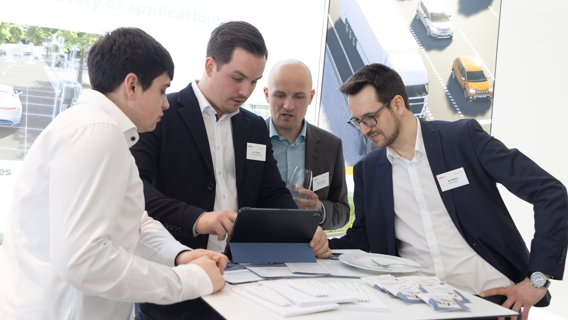 Vier Herren im Gespräch an einem Ausstellungsstand.