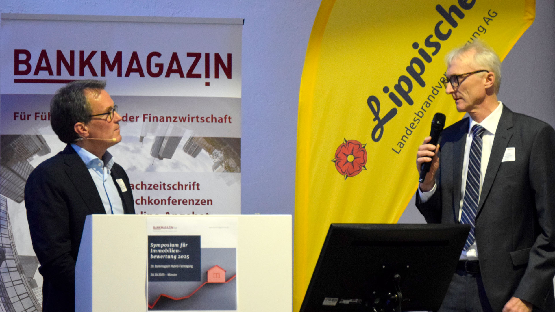 Moderator und Referent während Fragerunde auf der Bühne